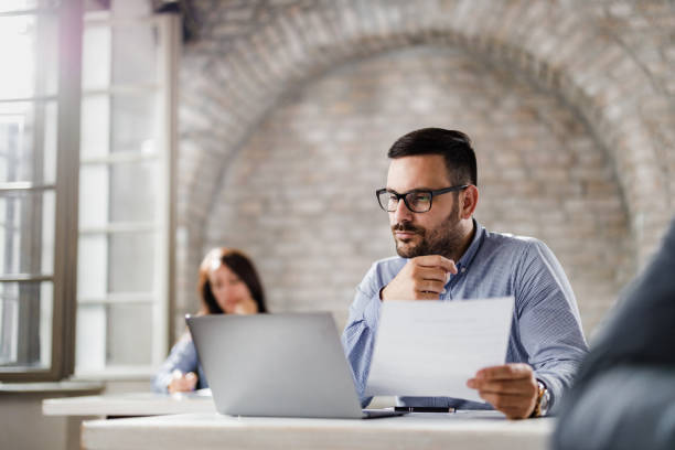 istock Young businessman working on laptop and paperwork in the office. 1436701730