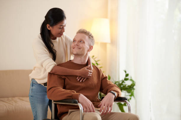 istock Man in Wheelchair and His Caring Girlfriend 1436703521
