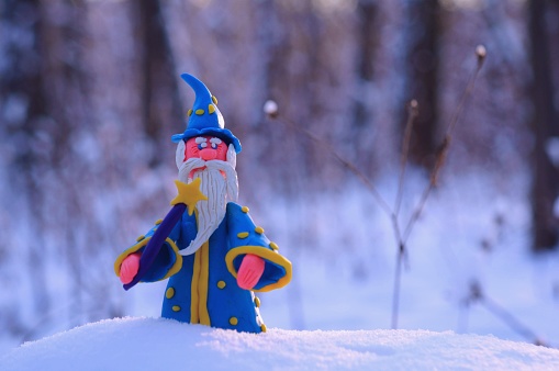 Figure of a wizard in the winter forest. A fairy-tale character.