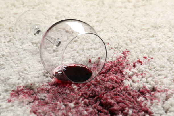 istock Overturned glass and spilled red wine on white carpet, closeup 1436707953