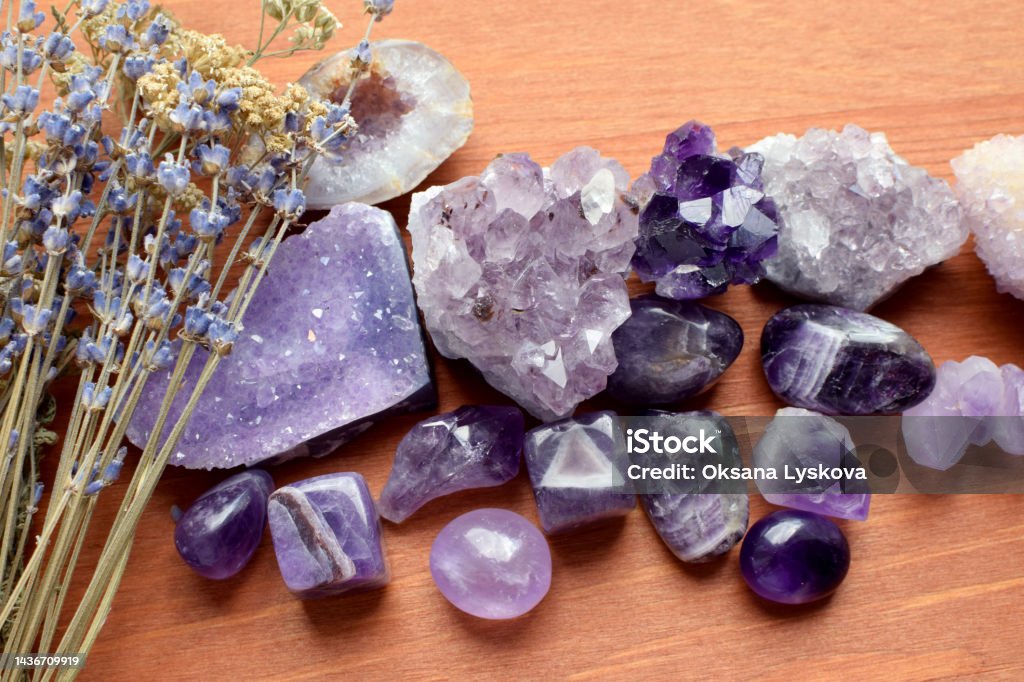 Beautiful amethyst stones and amethyst druze with dry lavender bouquet on wooden background. Magic amulets. Amethyst Stock Photo