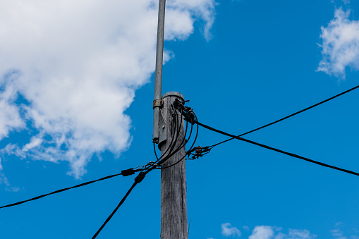 Electrical telephone wires against a blue sky.