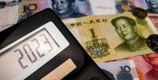 next fiscal year 2023 on the calculator screen against the background of chinese banknotes and coins - investment rmb savings china imagens e fotografias de stock