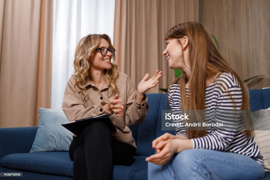 Encouraging therapist talks with young woman Mental Health Professional Stock Photo