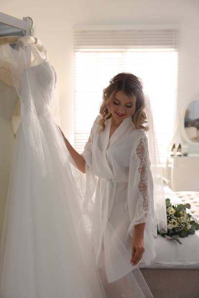 istock Beautiful bride with her white wedding dress at home 1436715562