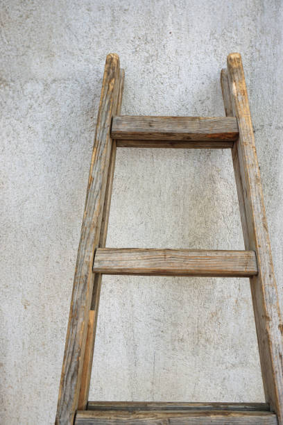 istock Wooden weathered ladder leaning against the wall. 1436716152