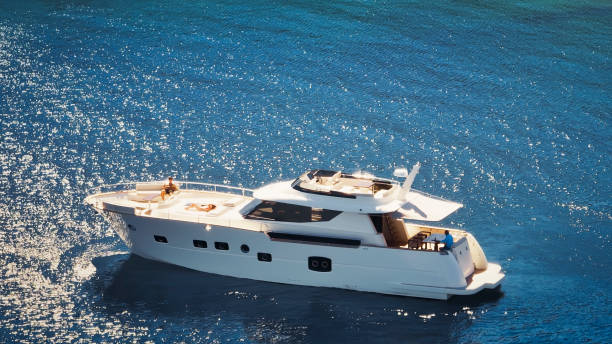 Aerial view of couple sunbathing on luxury yacht in sea.