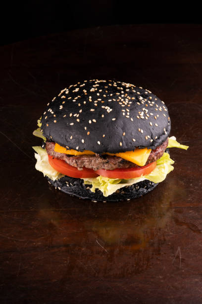 ハロウィーンをテーマにしたハンバーガー、チーズトマトブラックバンズレタス、キャットテールにガーギリンを添えて角度を分けた - hamburger bun bread isolated ストックフォトと画像