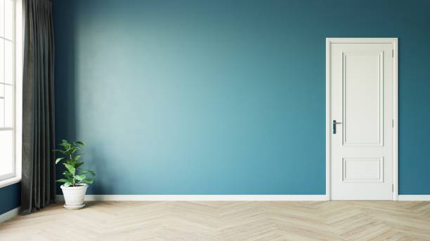 istock Modern style empty blue room with wooden floor window sun light effect with a plant next to a dark luxurious curtain on the left and white door on the right. 3d illustration. 1436723567