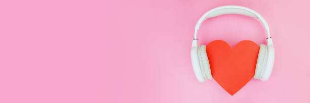 istock White wireless headphones are put on a red heart on a pink background 1436726614