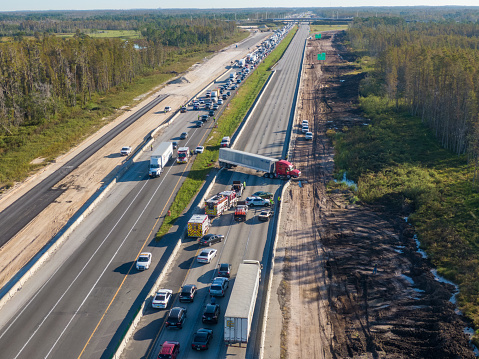 LAKE ALFRED, Fla., USA – OCT. 26, 2022: Westbound truck crossed I4 Eastbound shutting down freeway. Traffic building up. Emergency vehicles are working.