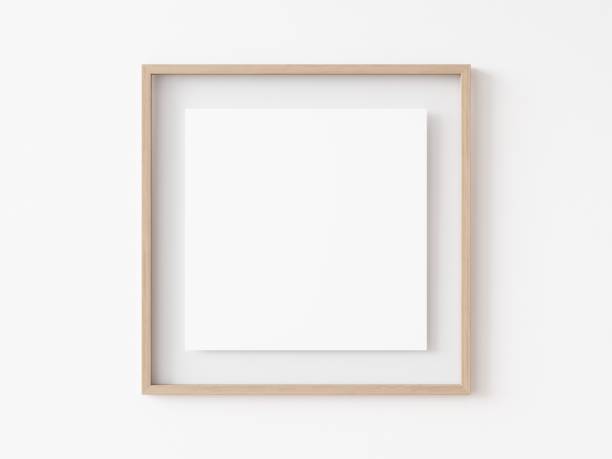 istock Empty square light wood picture frame with white center hanging on white wall. 3D Illustration. 1436728143