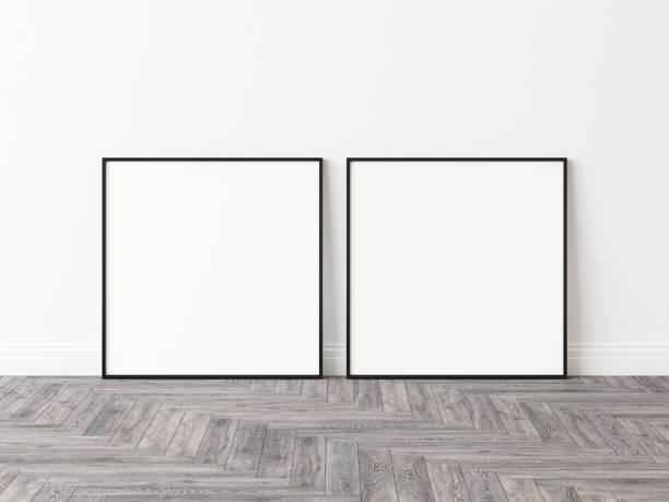 istock Two empty square picture frames with thin black border standing on wooden parquet floor leaning on white wall. 3D Illustration. 1436728240