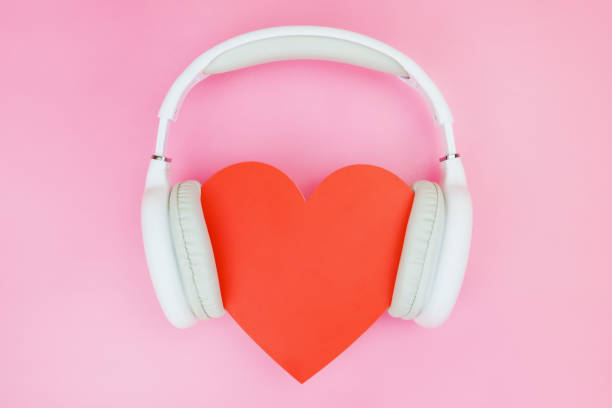 białe słuchawki bezprzewodowe są umieszczone na czerwonym sercu na różowym tle - valentines day hearts audio zdjęcia i obrazy z banku zdję�ć