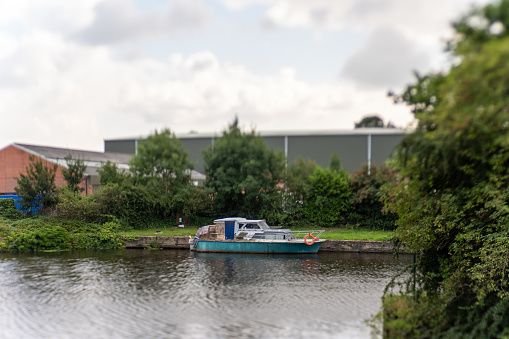 run down house boat moored in a Yorkshire industrial canal. Taken with a Lensbaby for intentional blur