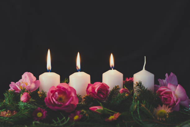 advent wreath with four candles, 3rd candle burning stock photo