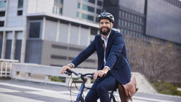 istock Young businessman smiling while riding his bike after work 1436730712