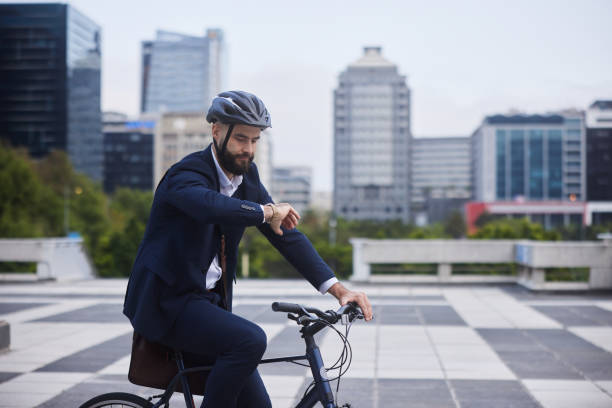 istock Businessman checking the time while riding his bike after work 1436732192