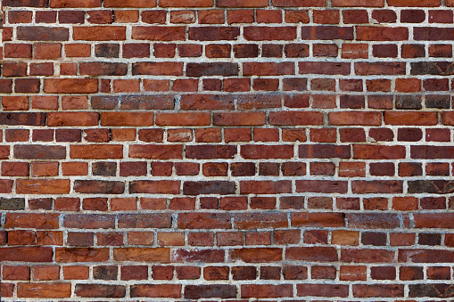 Old retro wall of red briks tiled background, regular block texture. Wallpaper of terracotta rustic wall surface