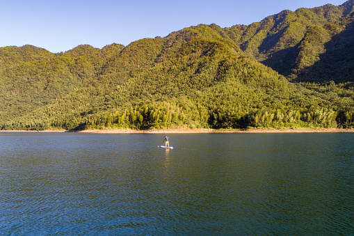 man paddling SUP in lake