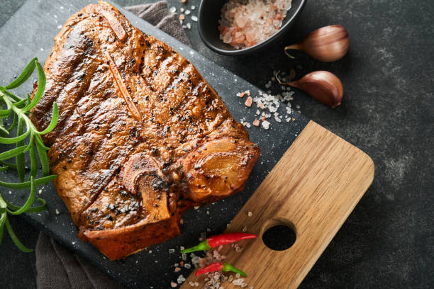 Raw steak t-bone or porterhouse. Steak t-bone or porterhouse in sauce with spices, salt and rosemary on a black ceramic plate on concrete background. Top view. Place for text. Raw steak t-bone or porterhouse. Steak t-bone or porterhouse in sauce with spices, salt and rosemary on a black ceramic plate on concrete background. Top view. Place for text. porterhouse steak stock pictures, royalty-free photos & images