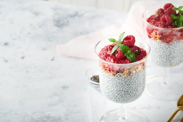istock Chia pudding. Healthy vanilla chia pudding in glass with fresh raspberries and mint on white background. Vegan healthy breakfast. 1436735429