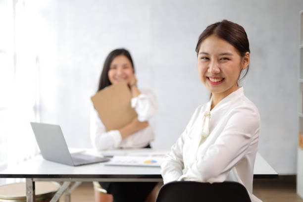 porträt einer glücklich lächelnden asiatischen geschäftsfrau, die mit kollegen im büro arbeitet. - private secretary stock-fotos und bilder