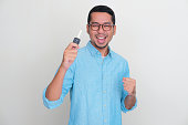 Adult Asian man holding car key with excited expression