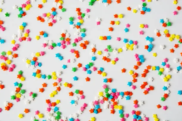 Multi-colored sugar small stars for sprinkling sweets on a white background. Isolated.