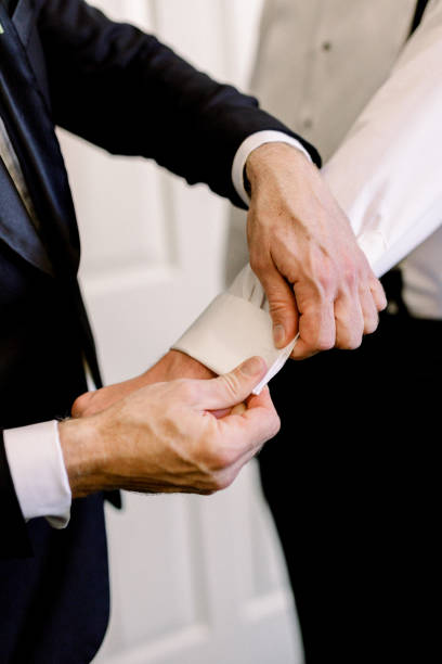 istock Man getting help with his cufflinks on his suit shirt 1436743872