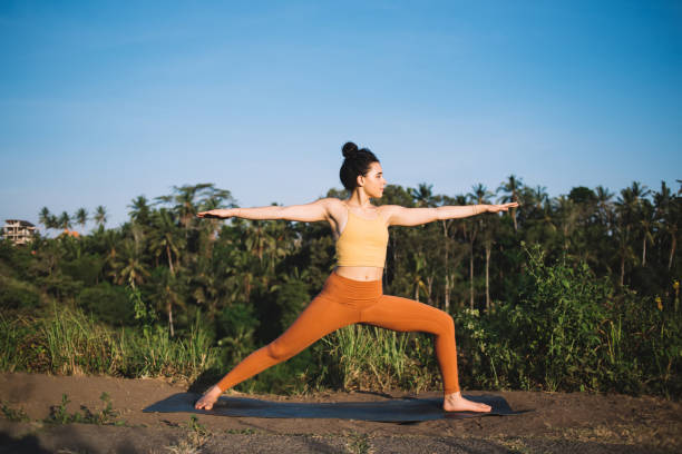 Concentrated positive caucasian girl in activewear enjoying yoga training on nature relaxing and feeling body vitality,calm woman standing in asana satisfied with relaxing practice on field in summer chica caucásica positiva concentrada en ropa activa disfrutando de entrenamiento de yoga en la naturaleza relajante y sensación de vitalidad corporal, mujer tranquila de pie en asana satisfecho con la práctica relajante en el campo en verano