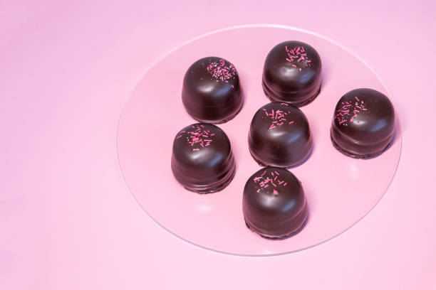 istock Sponge marshmallow candy covered in chocolate and vanilla wafer underneath, on a pink background. Copy space 1436743985