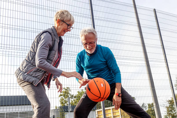 istock Mature couple play basket ball on playground 1436748064