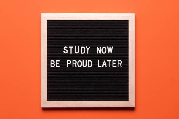 istock Motivational quote on black letter board on orange background. Study now be proud later. Inspirational quote of the day. 1436748575