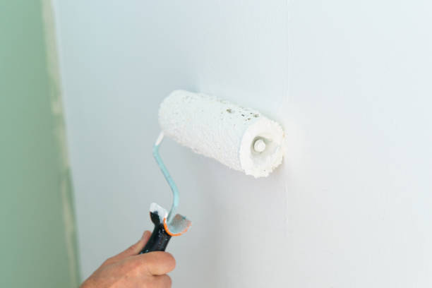 istock Close-up of hand painting the wall with a roller. Copy space. 1436756570
