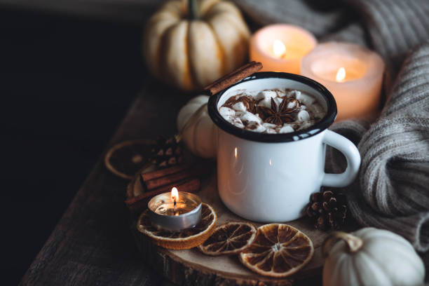 istock Autumn cozy home composition with hot chocolate with marshmallow and candles. Aromatherapy on a grey fall morning, atmosphere of cosiness and relax. Wooden background, window sill, close up. 1436757090