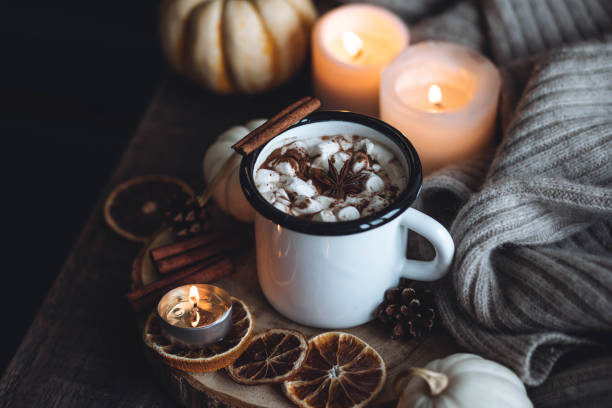istock Autumn cozy home composition with hot chocolate with marshmallow and candles. Aromatherapy on a grey fall morning, atmosphere of cosiness and relax. Wooden background, window sill, close up. 1436757092