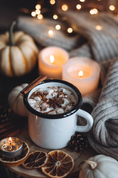 istock Autumn cozy home composition with hot chocolate with marshmallow and candles. Aromatherapy on a grey fall morning, atmosphere of cosiness and relax. Wooden background, window sill, close up. 1436757098