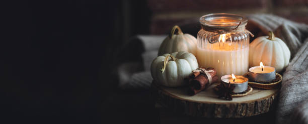 istock Autumn home composition with aromatic candle, dry citrus, cinnamon, anise. Aromatherapy on a grey fall morning, atmosphere of cosiness and relax. Wooden background close up banner copy space 1436757114