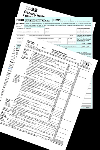 2022 IRS 1040 & schedule a tax forms on a black desktop.