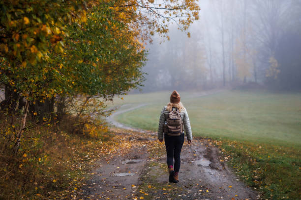 istock Woman hiking on footpath in autumn misty forest 1436763577