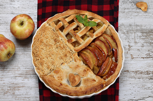 Piece of apple pie served with ice cream, fruit baking on wooden background, top view