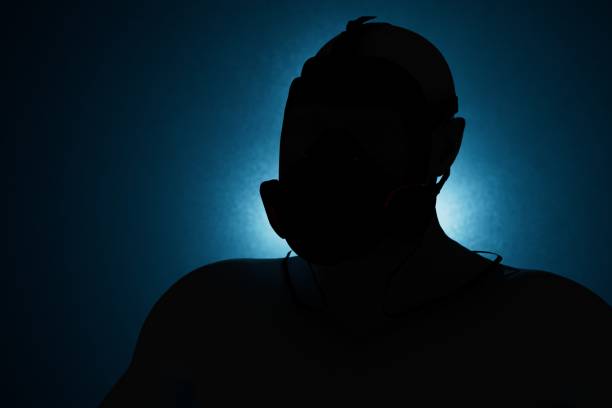 the black silhouette of a man in a mask illuminated with blue neon light on a black background. 3D render the black silhouette of a man in a mask illuminated with blue neon light on a black background. 3D render. vendetta stock pictures, royalty-free photos & images