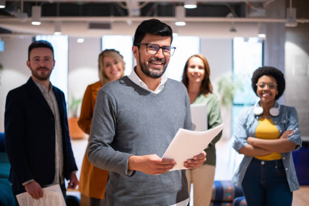 istock Happy business man leading a team at the office 1436767567