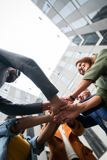 Happy Latin American business team in a circle with hands together in the middle â teamwork concepts