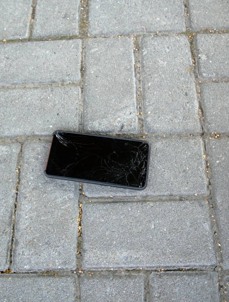istock A broken smartphone lies on the road, lined with paving slabs. Cracked mobile phone screen. vertical photo 1436768546
