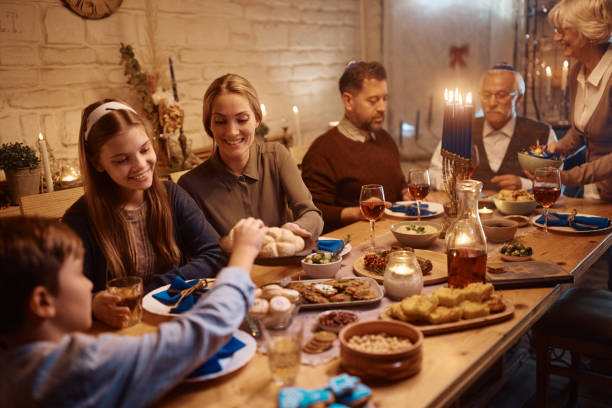 família judia feliz desfrutando na refeição na mesa de jantar em hanukkah. - jewish tradition - fotografias e filmes do acervo