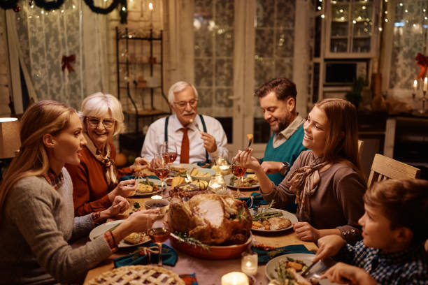 istock Happy multi-generation family enjoying in Thanksgiving dinner at dining table. 1436773261