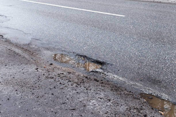 istock Dirty rural road with puddles and potholes 1436774742