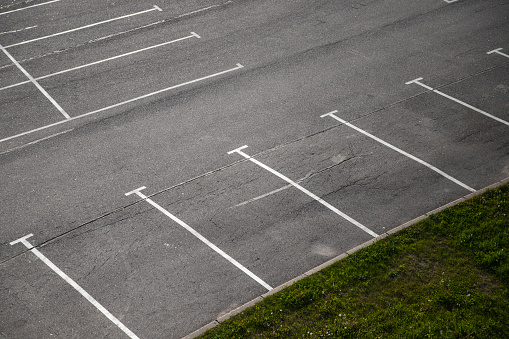 Empty parking lot, white road marking lines go over gray asphalt pavement, abstract transportation background photo